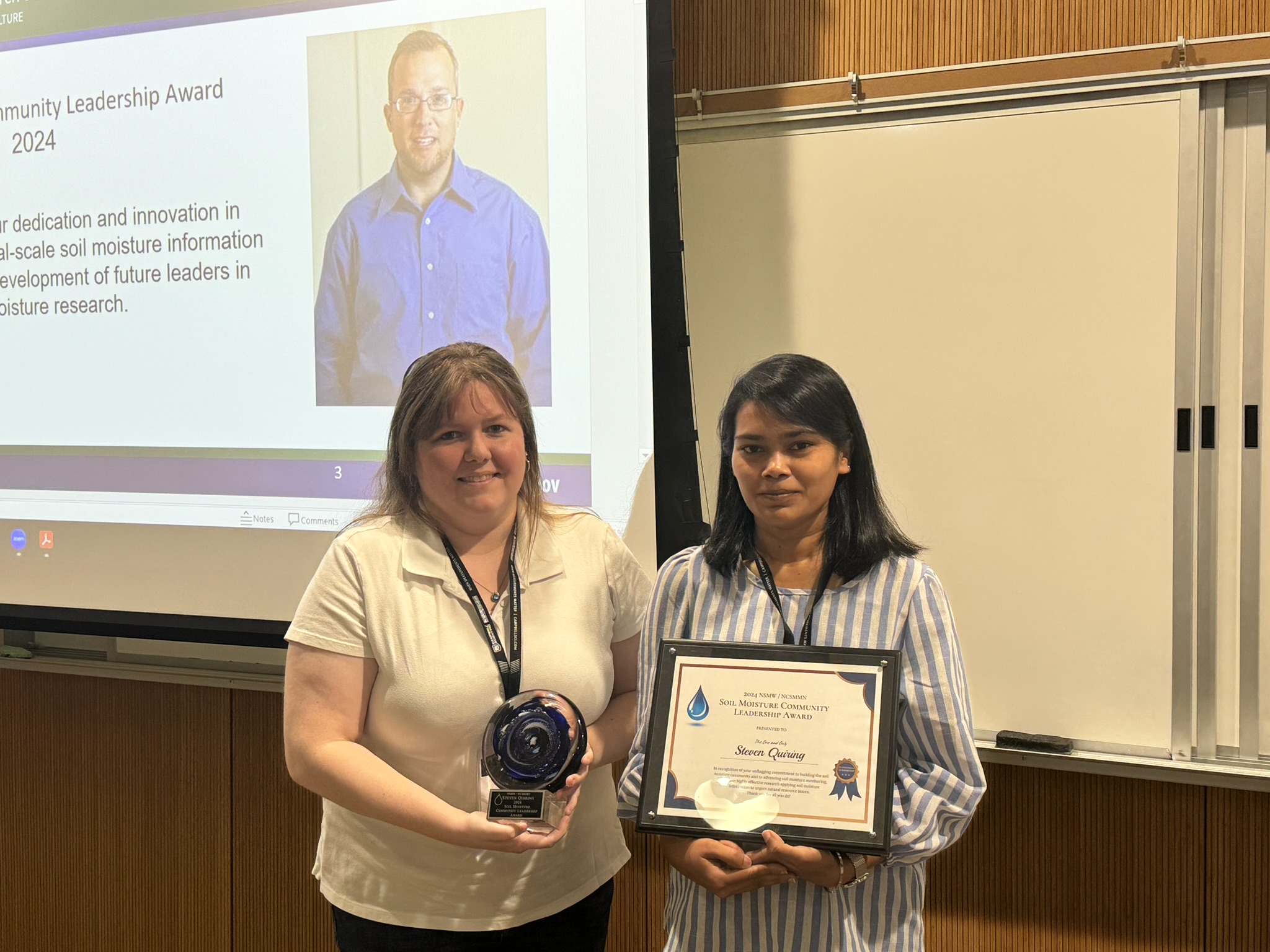 Graduate students of Dr. Steven Quiring accept the award on his behalf.