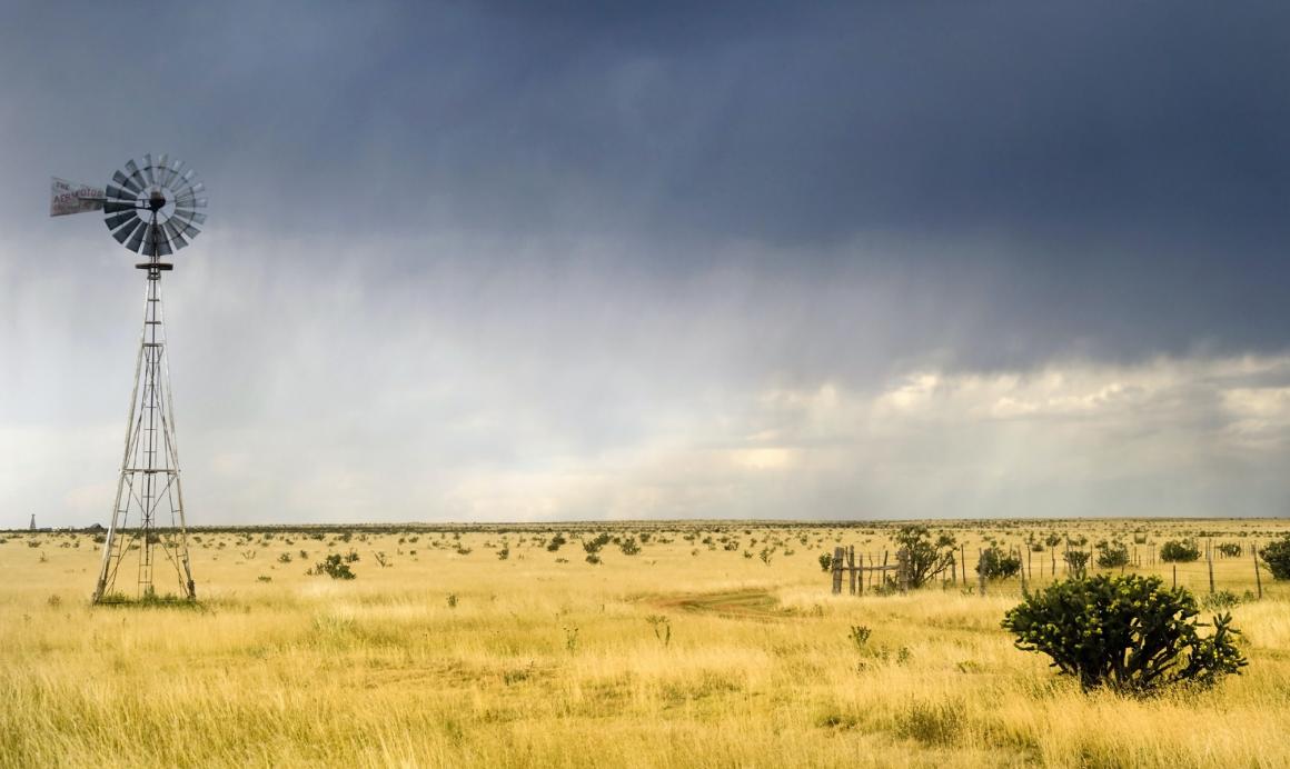 Windmill in a Texas field with a storm approaching