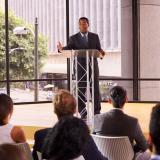 A speaker gives a presentation to a crowd of people, representing communication and knowledge exchange. Photo credit: Shutterstock, Monkey Business Images.